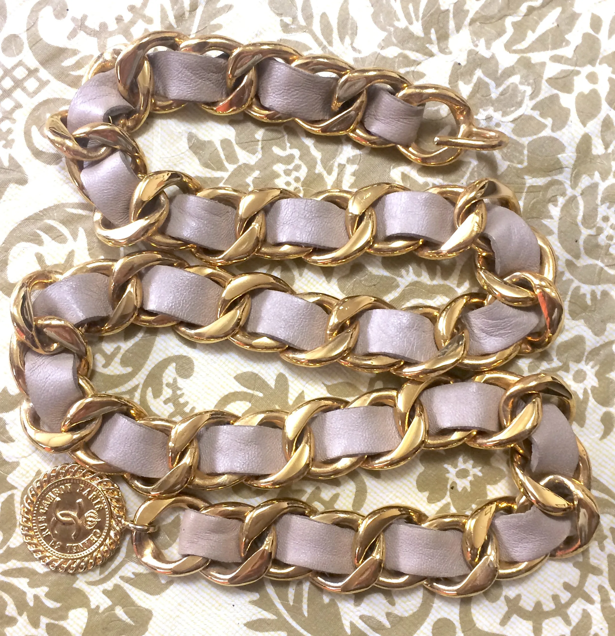 80's Vintage CHANEL beige leather thick chain belt with golden CC and mademoiselle charm. Nice and heavy single layer belt from CHANEL.